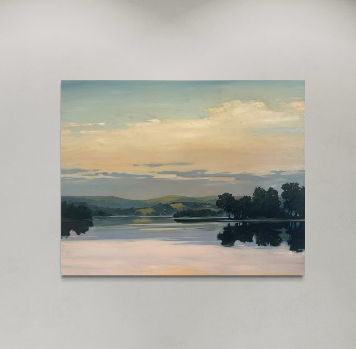Painting of a landscape with a lake and trees on a gray wall.