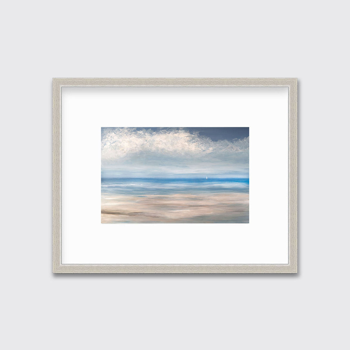 A blue, white and beige seascape print in a silver frame with a mat hangs on a white wall.
