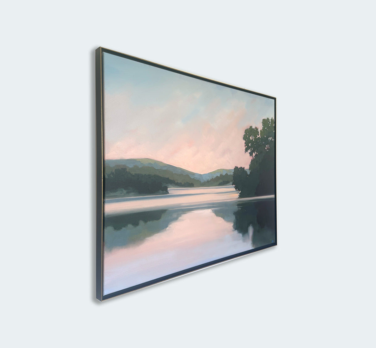 Framed artwork of a landscape with trees and water on a light gray background