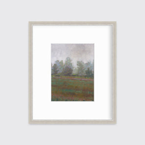 A grey and muted green abstract landscape print in a silver frame with a mat hangs on a white wall.