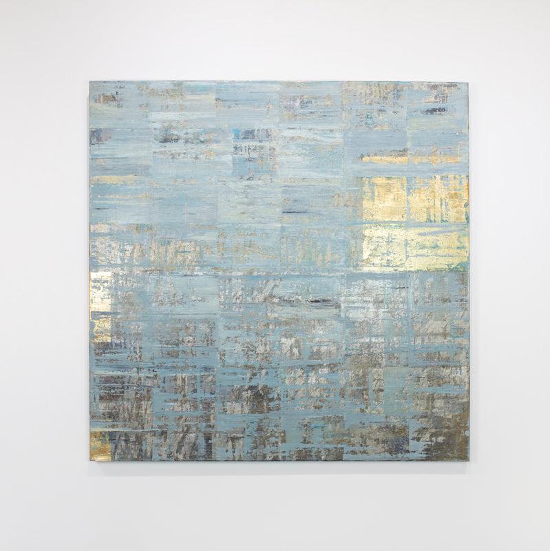 A blue and gold abstract painting hangs on a white wall.