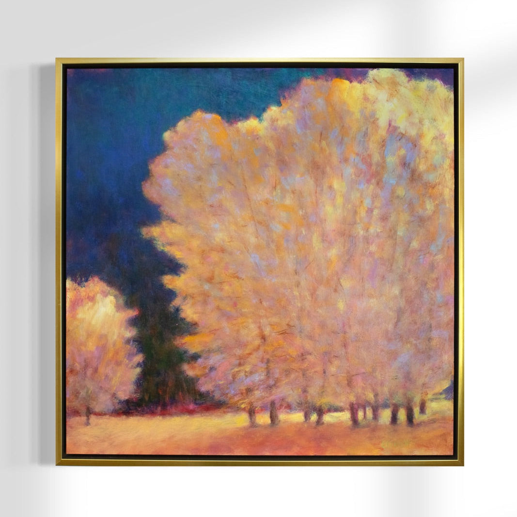 Framed painting of trees with autumn foliage on a white wall