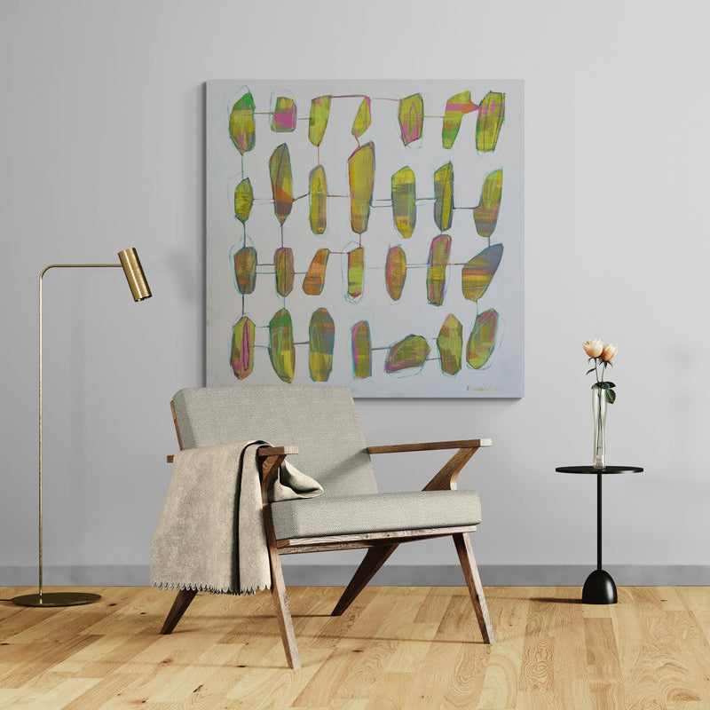Modern living room with a chair, side table, and abstract art on a gray wall.