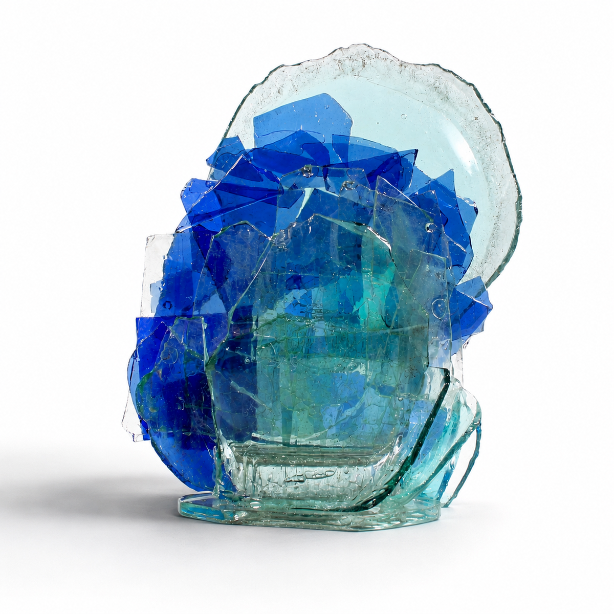 Glass sculpture with blue and green crystal-like formations on a white background
