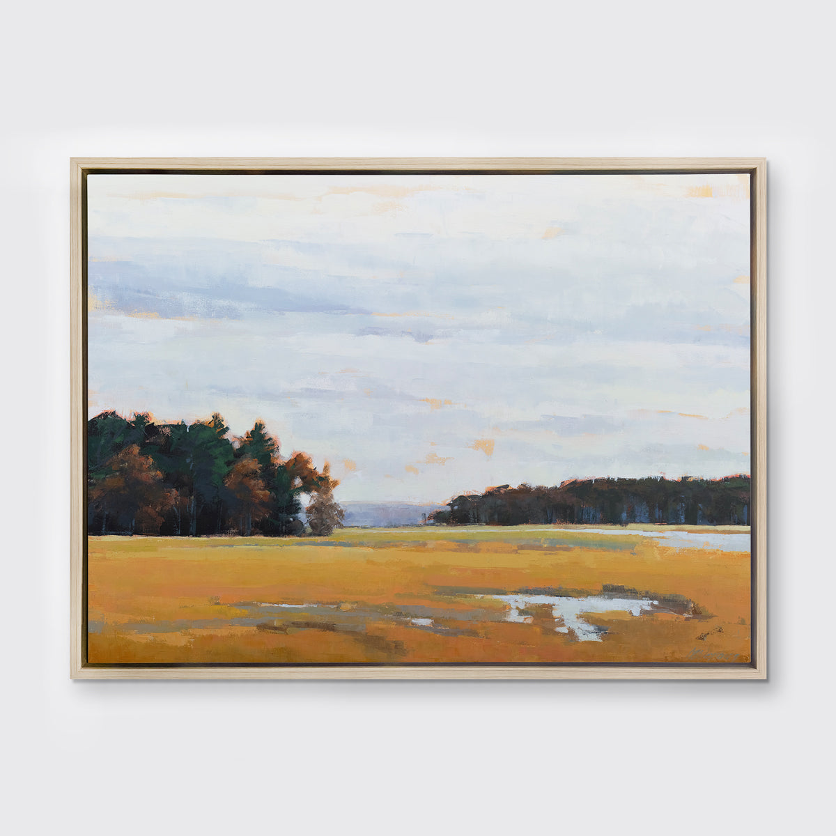A landscape print in a white oak wood floater frame hangs on a white wall.