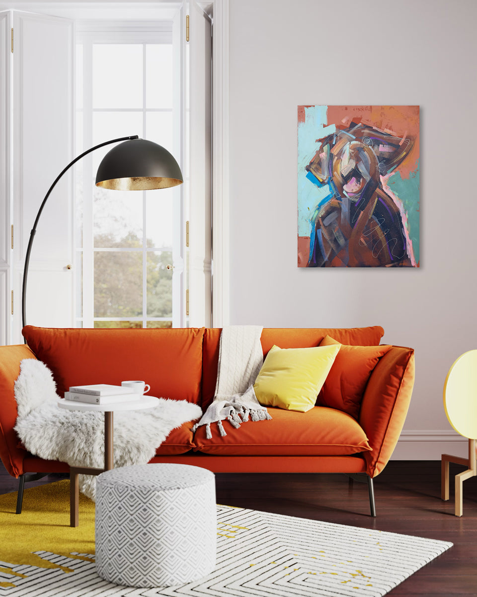 An abstracted painting of a dog hangs on a light wall above an orange couch with yellow accent pillows and a geometric area rug and modern decor.