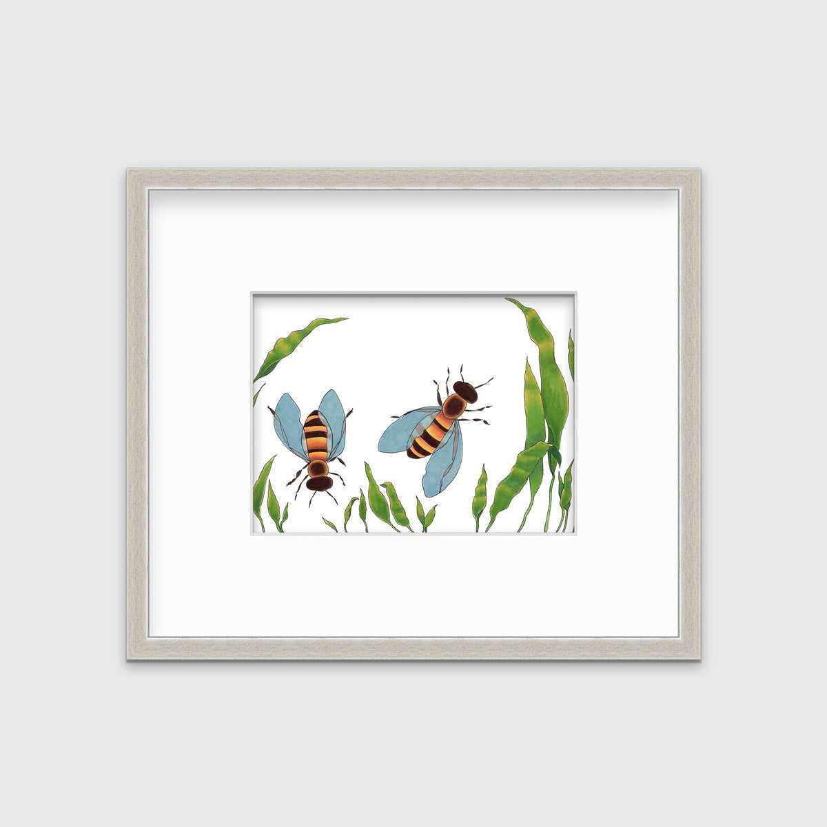 A minimalist bee illustration print in a silver frame with a mat hangs on a white wall.