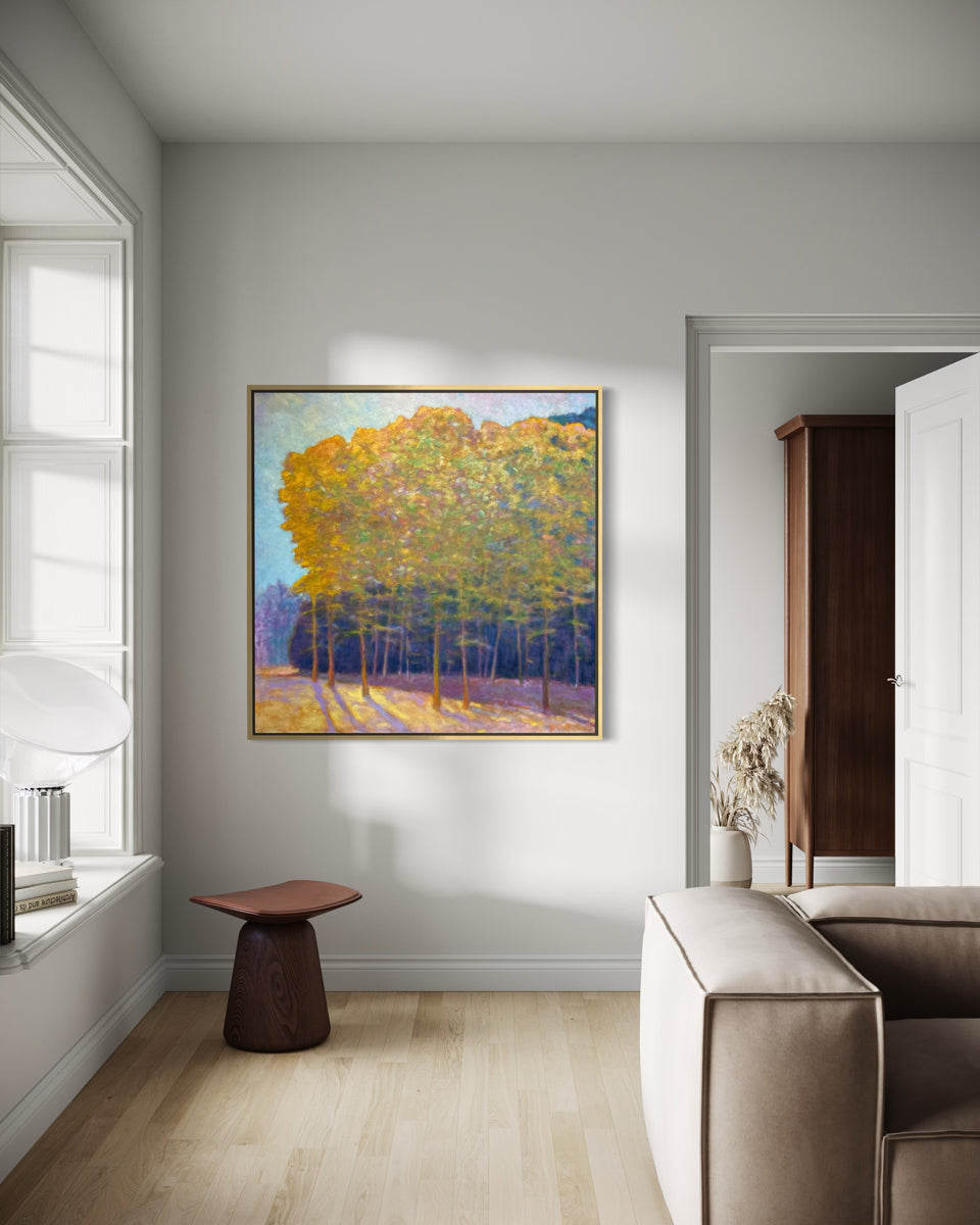 Modern living room with a painting of trees on a wall, a brown stool, and a beige sofa.