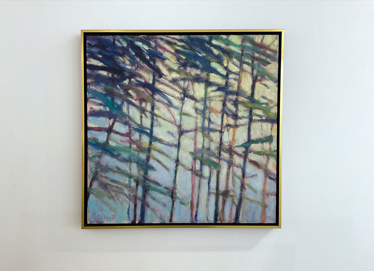 Framed abstract landscape painting with trees on a white wall