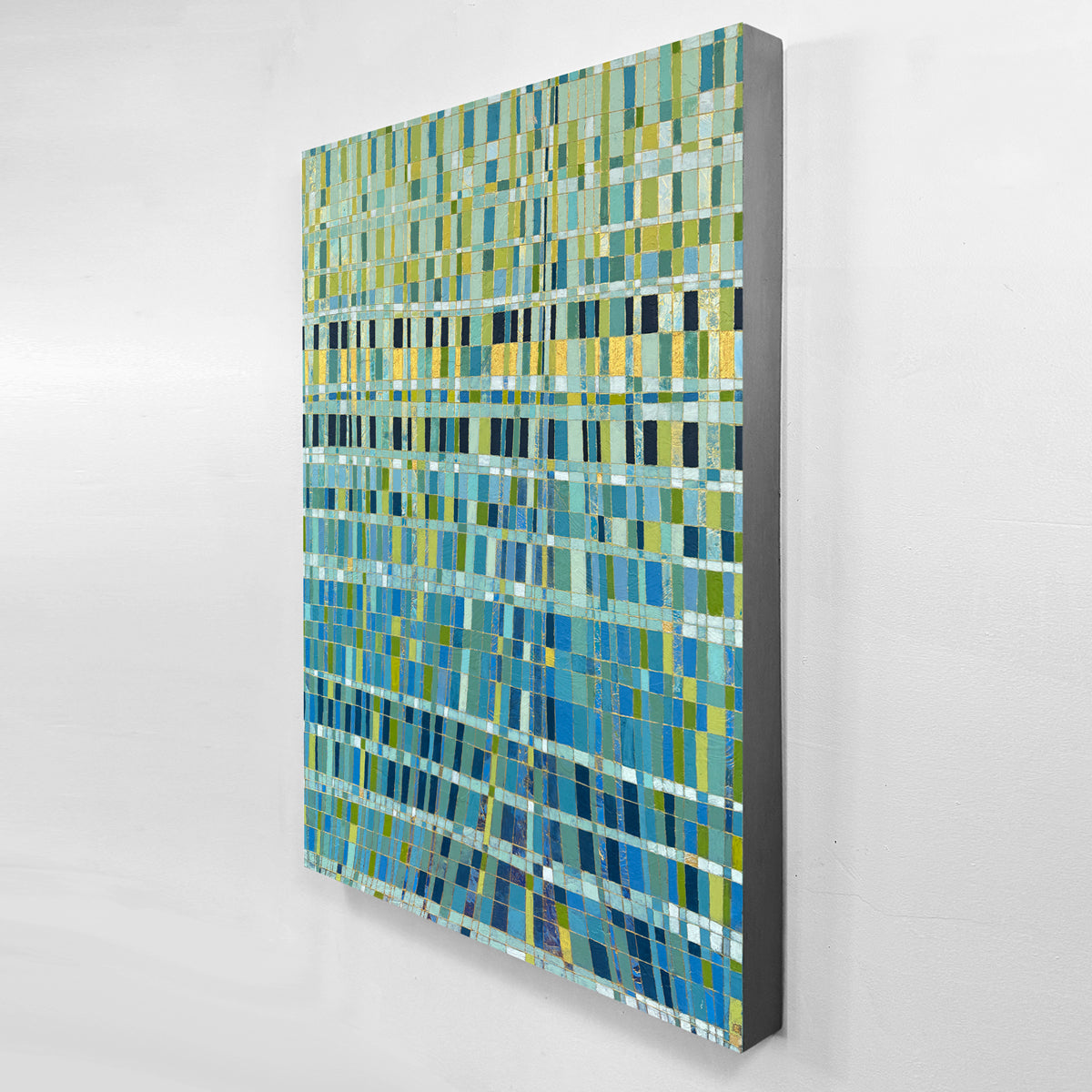 An abstract canvas painting featuring a textured mosaic pattern of blue, green, and yellow horizontal rectangles, displayed against a clean white wall.