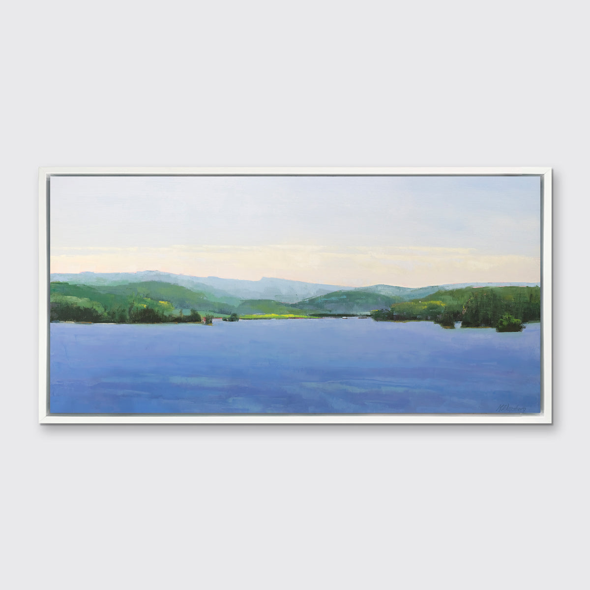 A blue landscape art print framed in a white floater frame hangs on a white wall.