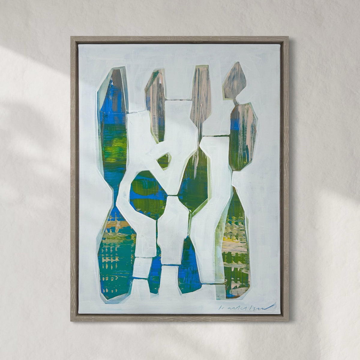 A framed abstract painting by Kayla Ackelson hangs on a white wall.