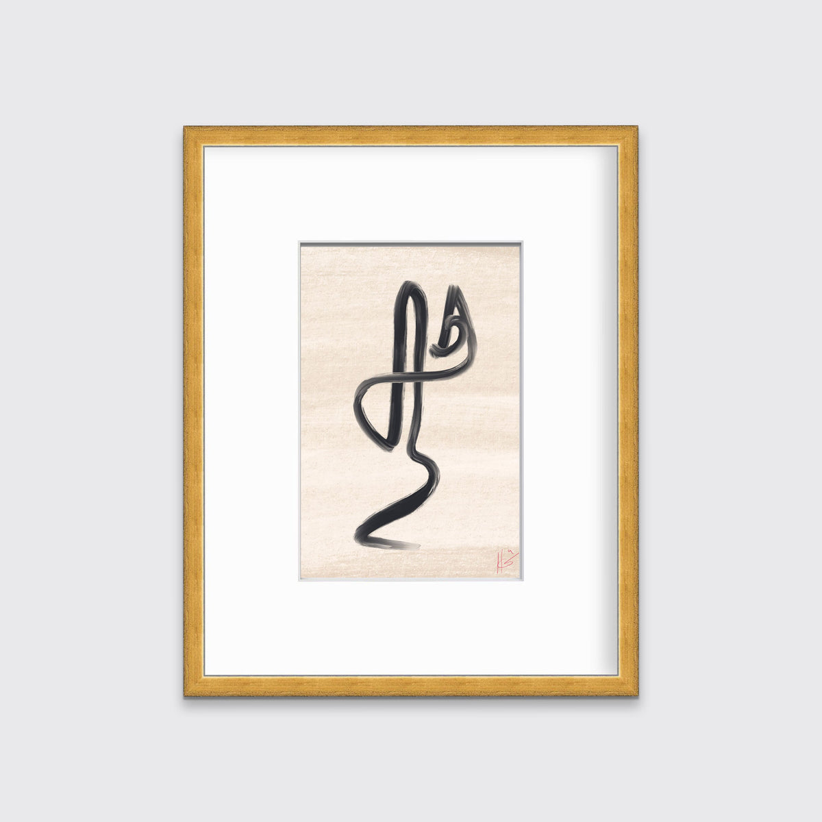 An abstract black and beige art print framed in a gold frame hangs on a light grey wall.