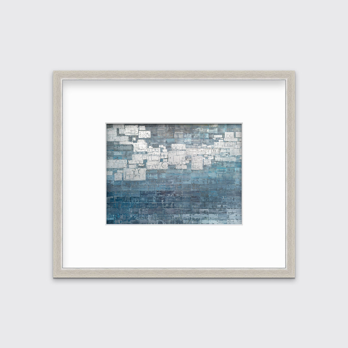 A blue, white and grey abstract print in a silver frame with a mat hangs on a white wall.