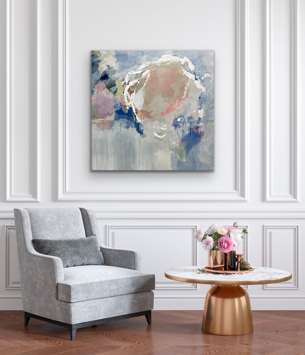 Modern interior with a gray armchair, marble table, and abstract painting on a white wall.