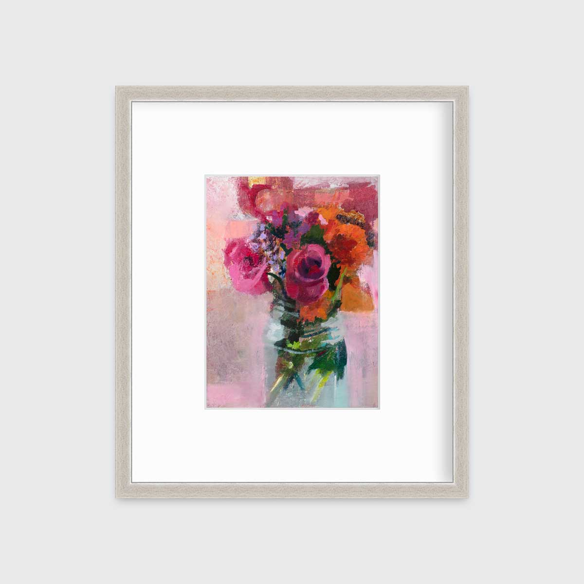 A pink, orange and green abstract floral print in a silver frame with a mat hangs on a white wall.