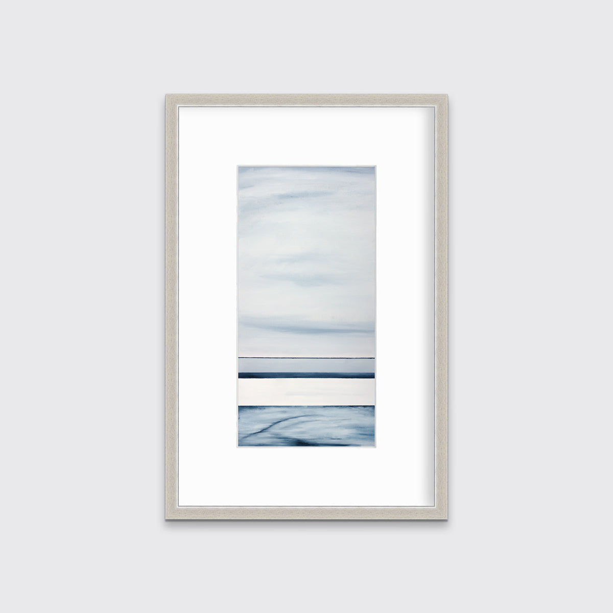 A blue-grey abstract print hangs in a silver frame with a mat on a white wall