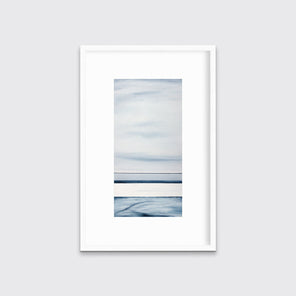 A blue-grey abstract print hangs in a white frame with a mat on a white wall