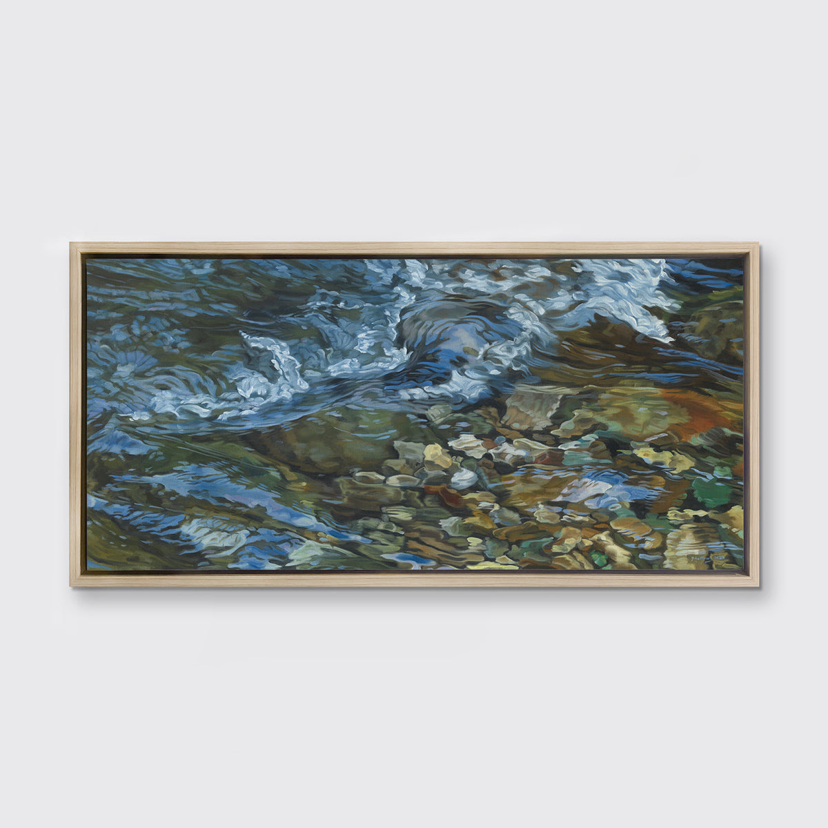 A painting of swirling water in a rocky riverbed hangs in a white oak frame on a white wall.