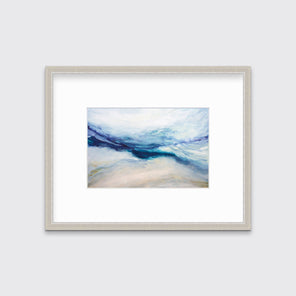 A white, blue, purple and beige abstract print in a silver frame with a mat hangs on a white wall.