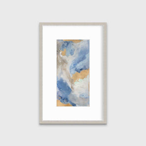A blue, teal, beige and gold abstract print in a silver frame with a mat hangs on a white wall.