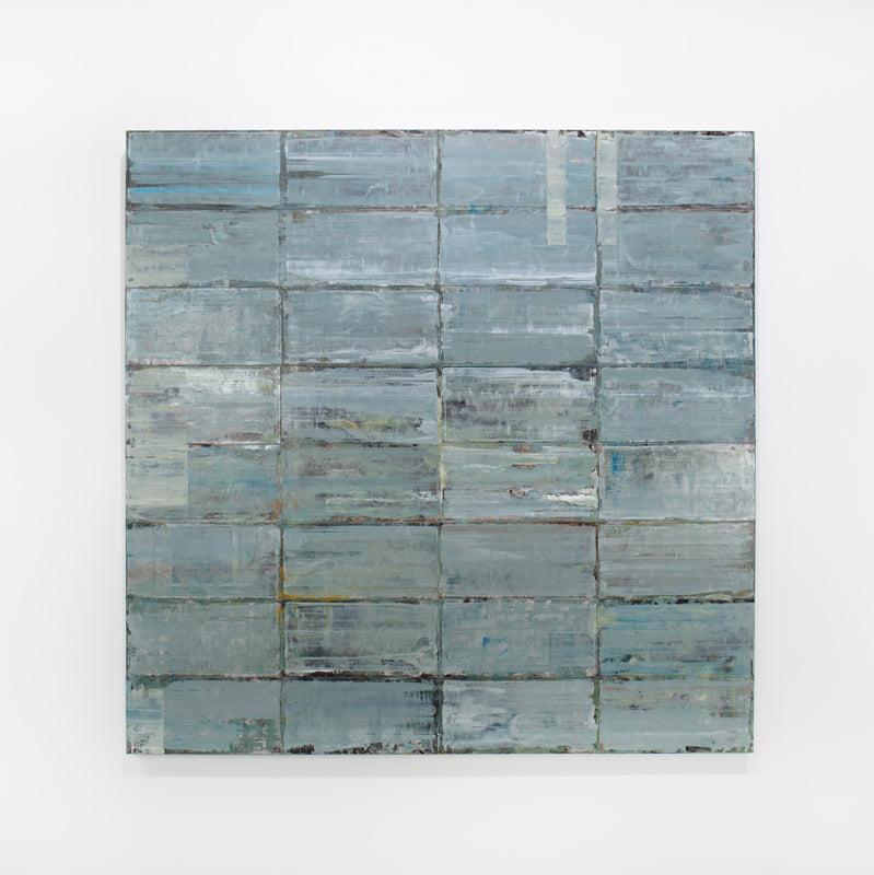 A blue and grey abstract geometric painting hangs on a white wall.