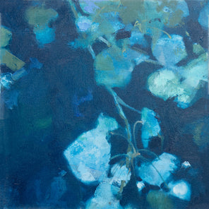 An abstract blue floral painting hangs on a white wall.