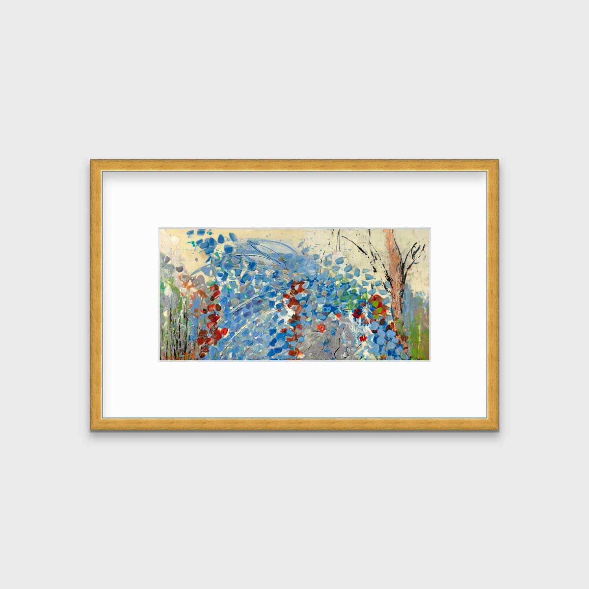 A blue, beige, green and black abstract print in a gold frame with a mat hangs on a white wall.