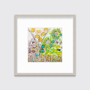 A yellow, green and red abstract floral print in a silver frame with a mat hangs on a white wall.