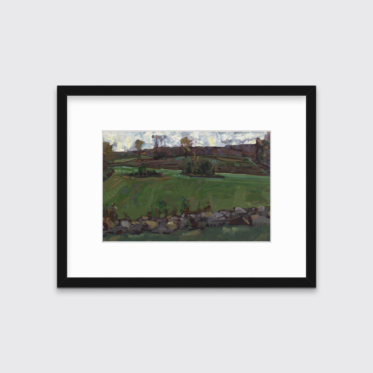 A green, brown and white abstract landscape print in a black frame with a mat hangs on white wall.