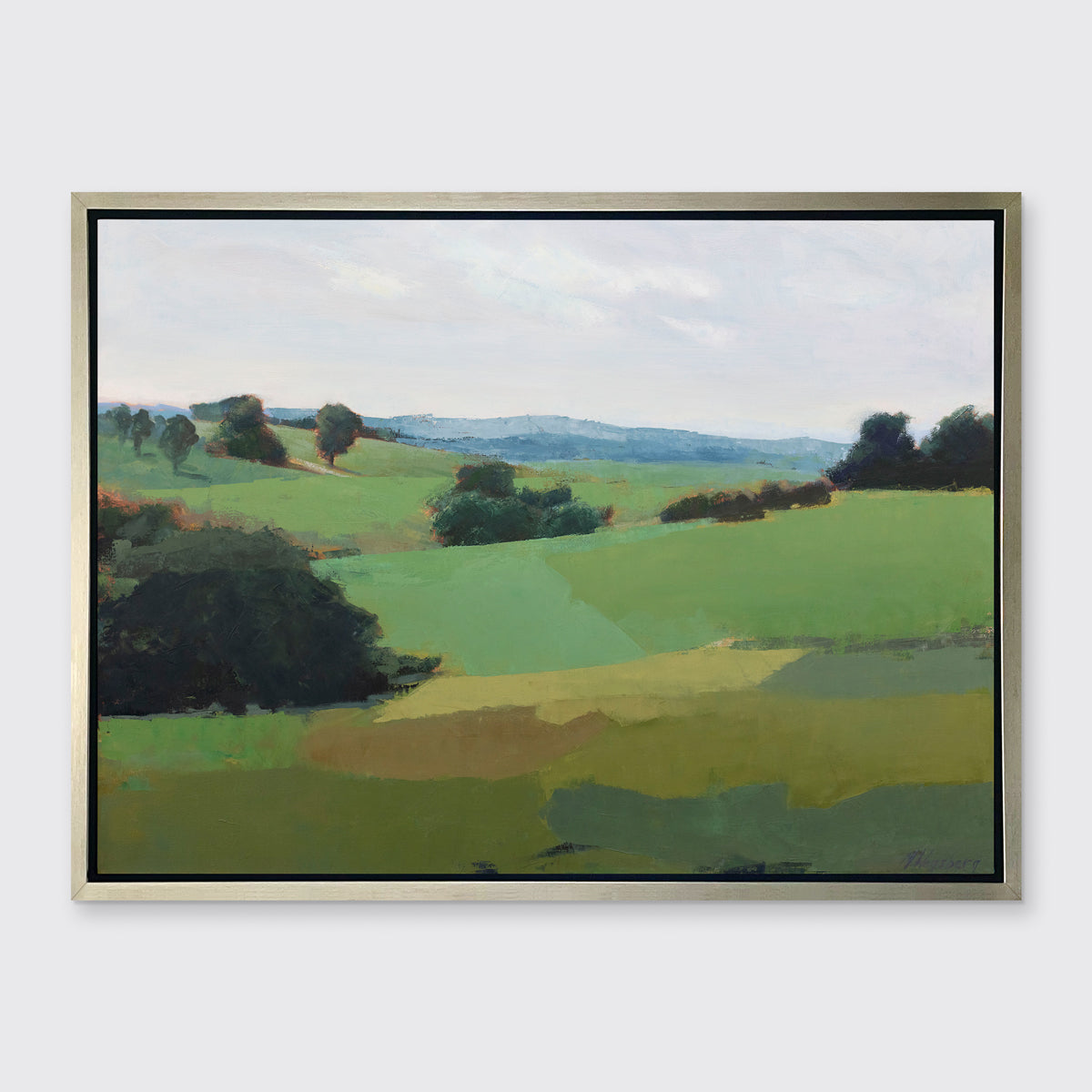A green limited edition landscape print in a silver frame hangs on a white wall.