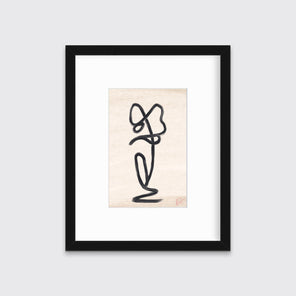A black minimalistic art print framed in a black frame hangs on a grey wall.