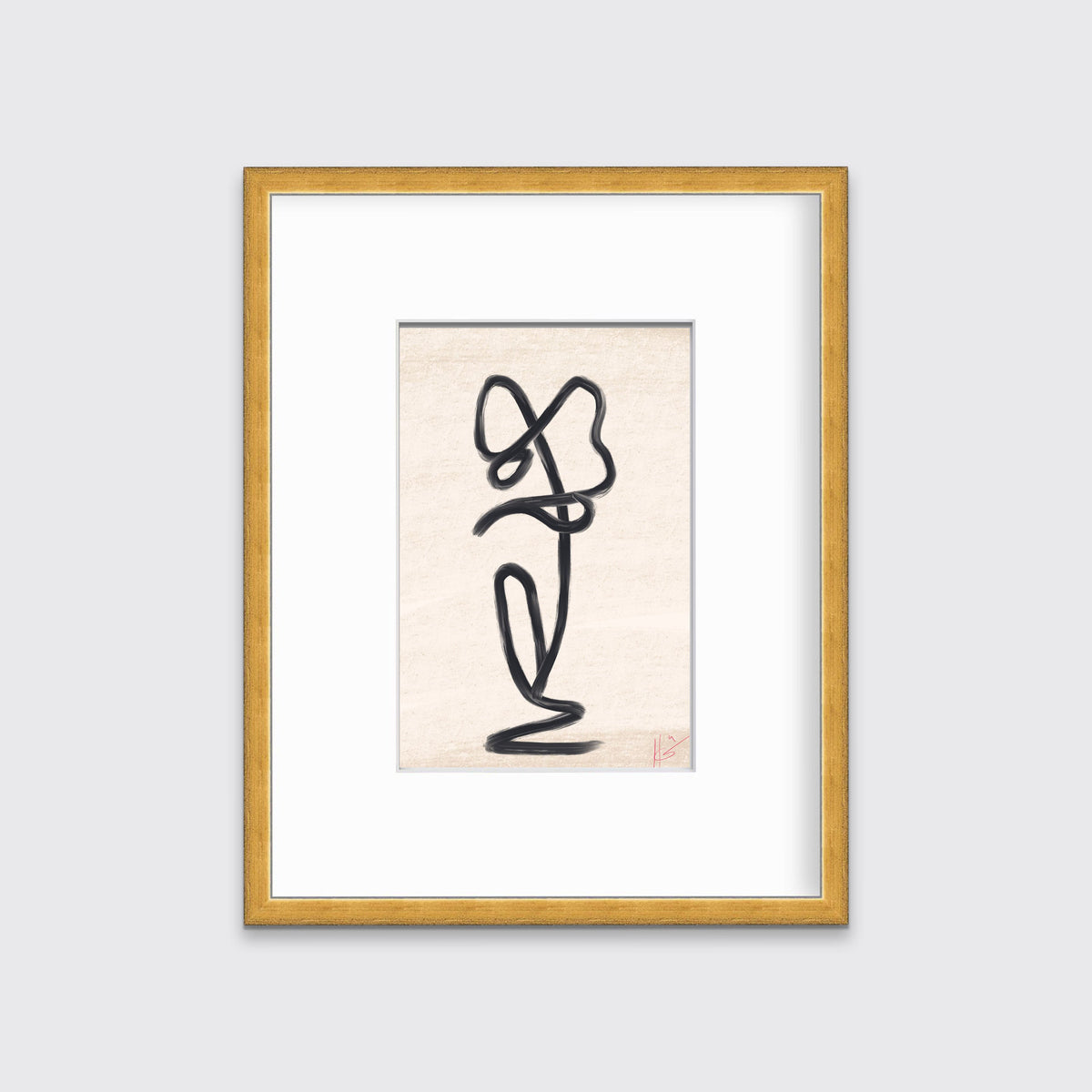 A minimalistic black and beige art print framed in a gold frame hangs on a light grey wall.