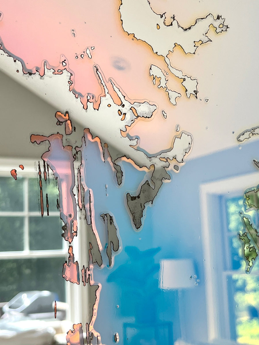 A detail of a fine art mirror reflecting the room it is in.