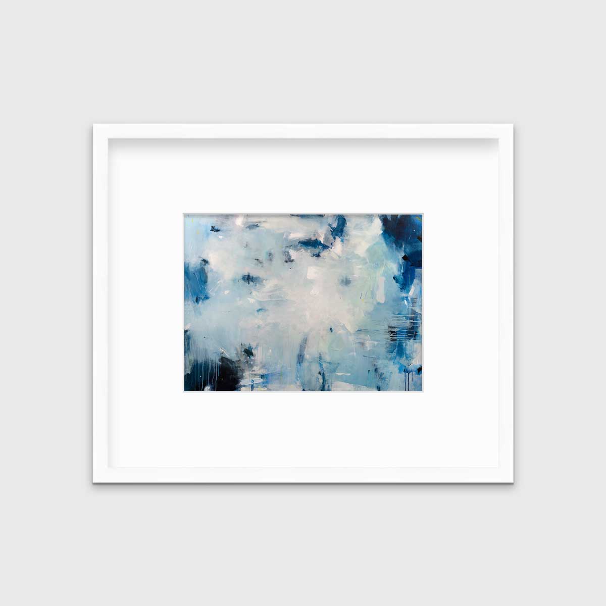 A blue and white abstract print by Kelly Rossetti in a white frame with a mat hangs on a white wall.