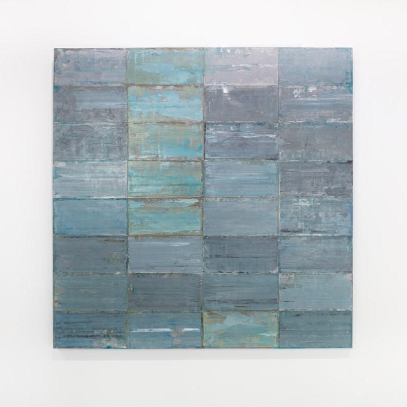 A blue and grey abstract geometric painting hangs on a white wall.