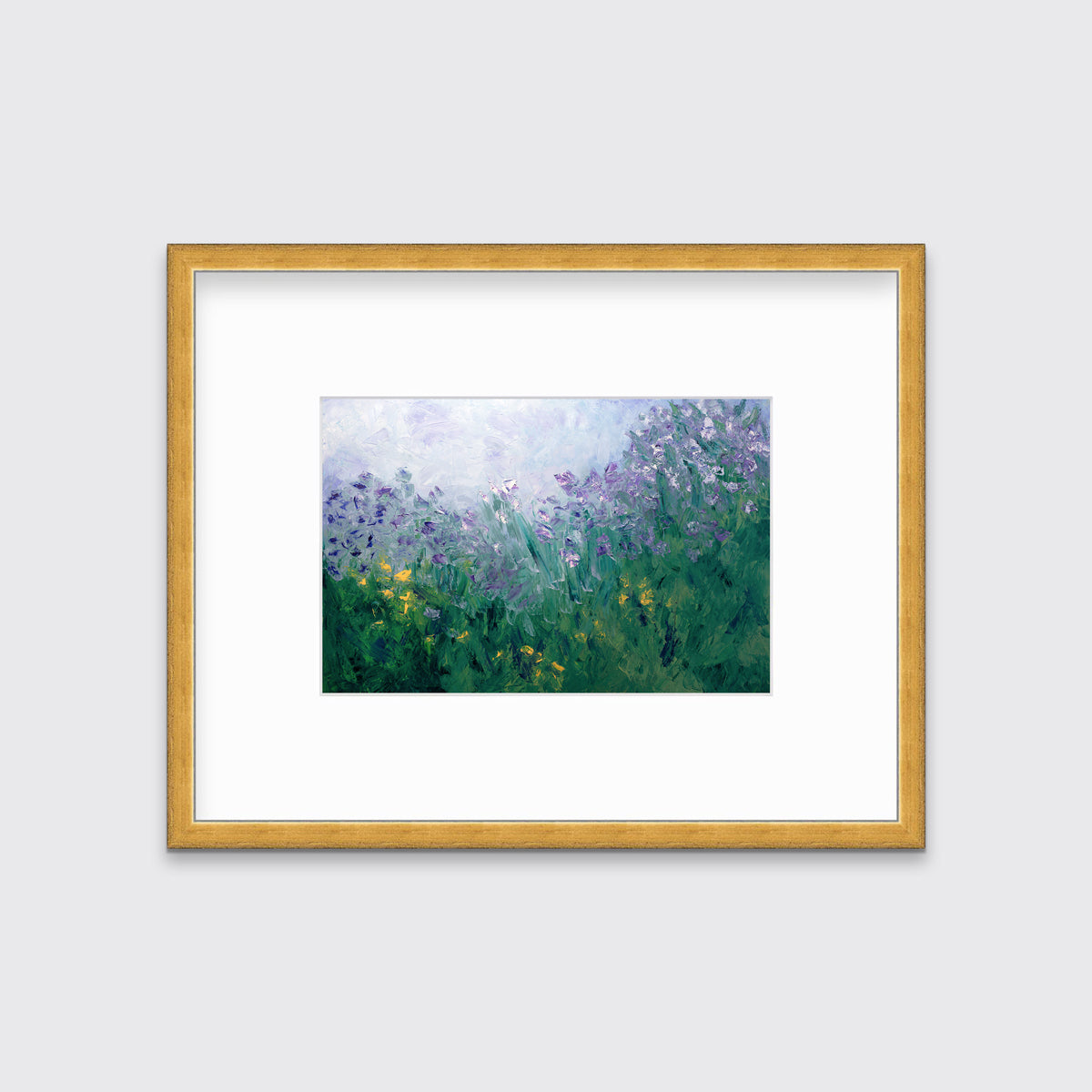A blue, purple and green abstract print in a gold frame with a mat hangs on a white wall.