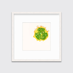 An abstract print of a fruit framed in a white frame hangs on a light wall.