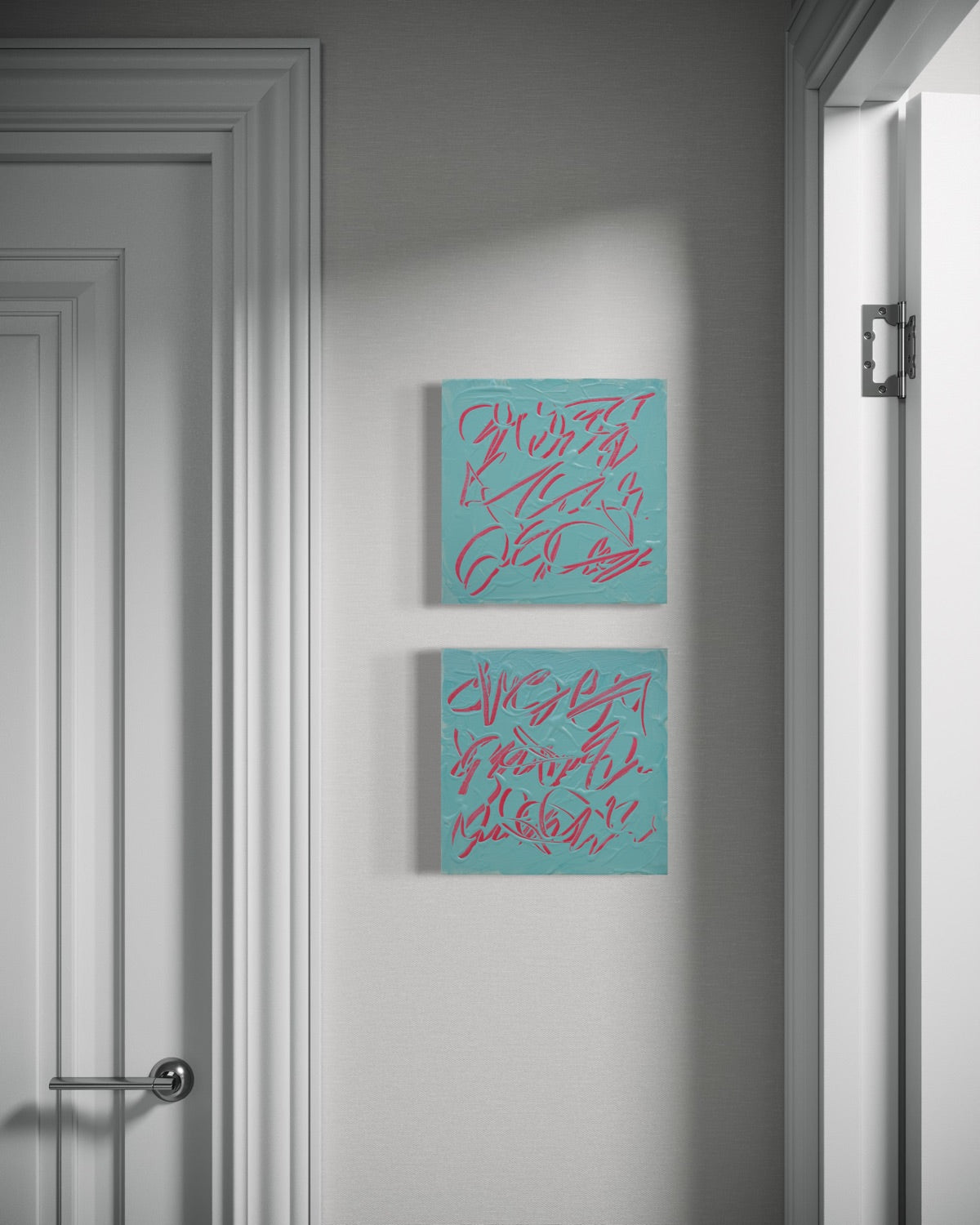 Two square texted based abstract paintings with textured teal backgrounds and pink abstract graffiti-style lettering, hanging vertically on a gray wall in a doorway.