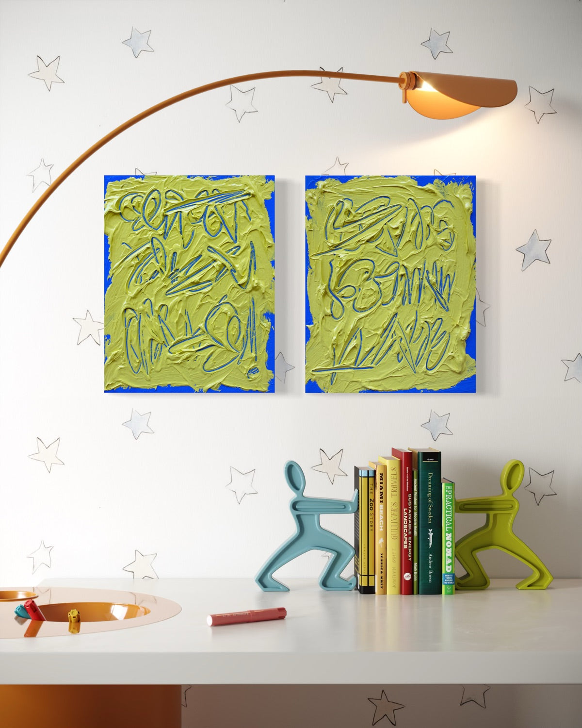 Two abstract text based painting featuring a thick, yellow-green impasto texture with blue abstract scribbled lines hang on a white wall above a desk. The scene includes a curved floor lamp, books, and decorative figurines, with a star pattern on the wall.
