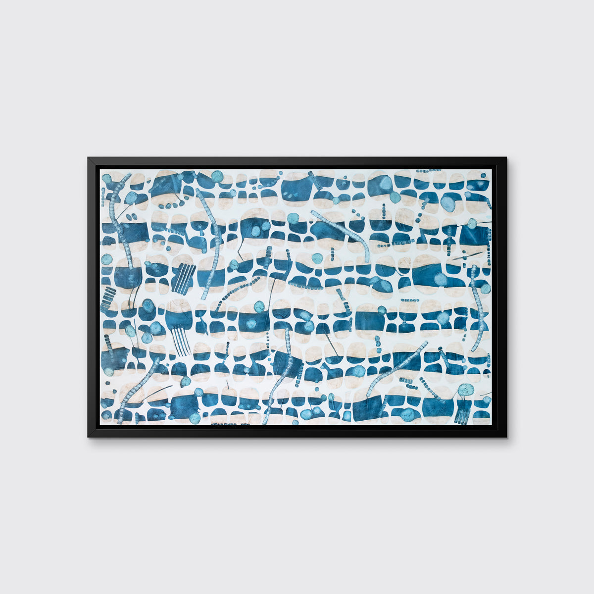 A blue, teal and beige geometric abstract print in a black floater frame hangs on a white wall.