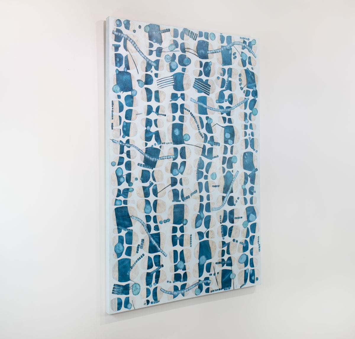 An abstract blue, white, and beige painting hangs on a white wall.