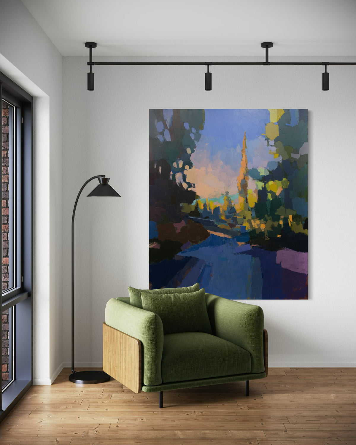 A large blue and yellow abstracted landscape painting hangs on a white wall above a green chair.