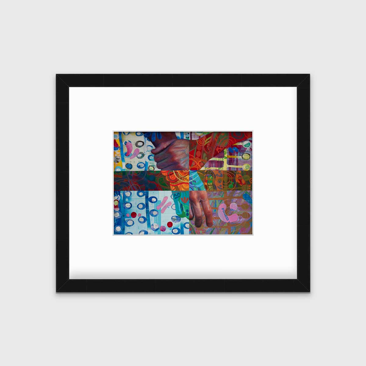 A multicolored abstract print of two hands in a black frame with a mat hangs on a white wall.