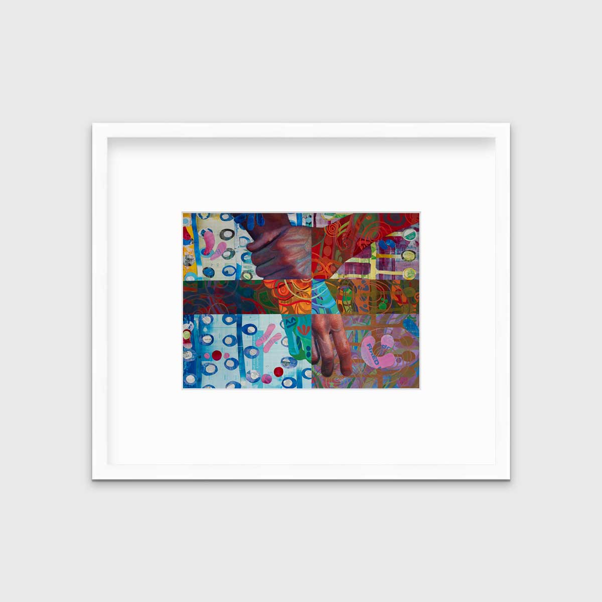 A multicolored abstract print of two hands in a white frame with a mat hangs on a white wall.