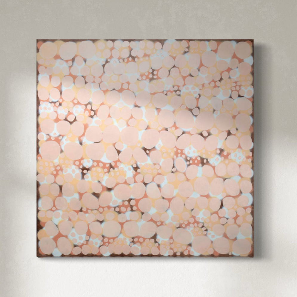 An orange, salmon, coral and pink abstract painting hangs on a white wall.