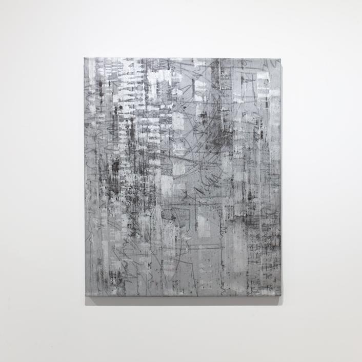 A black and silver abstract painting hangs on a white wall.