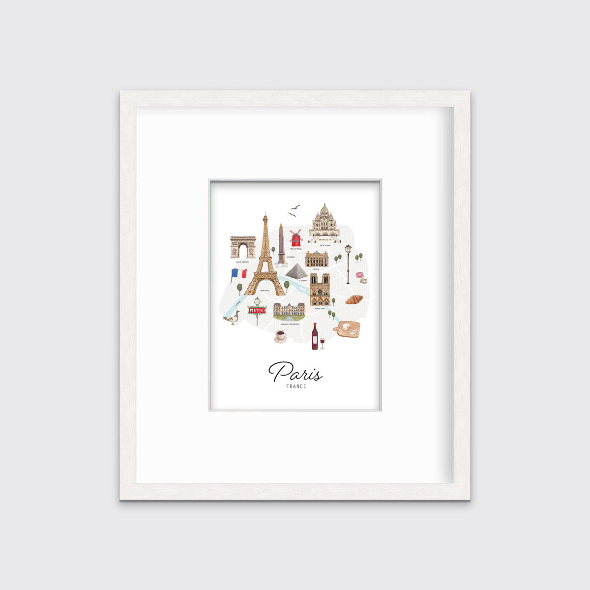 A multicolored map print of Paris, France with the famous landmarks in a whitewashed frame with a mat hangs on a white wall.