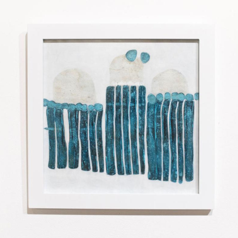 A blue, white, and beige abstract painting framed in a white frame hangs on a white wall.