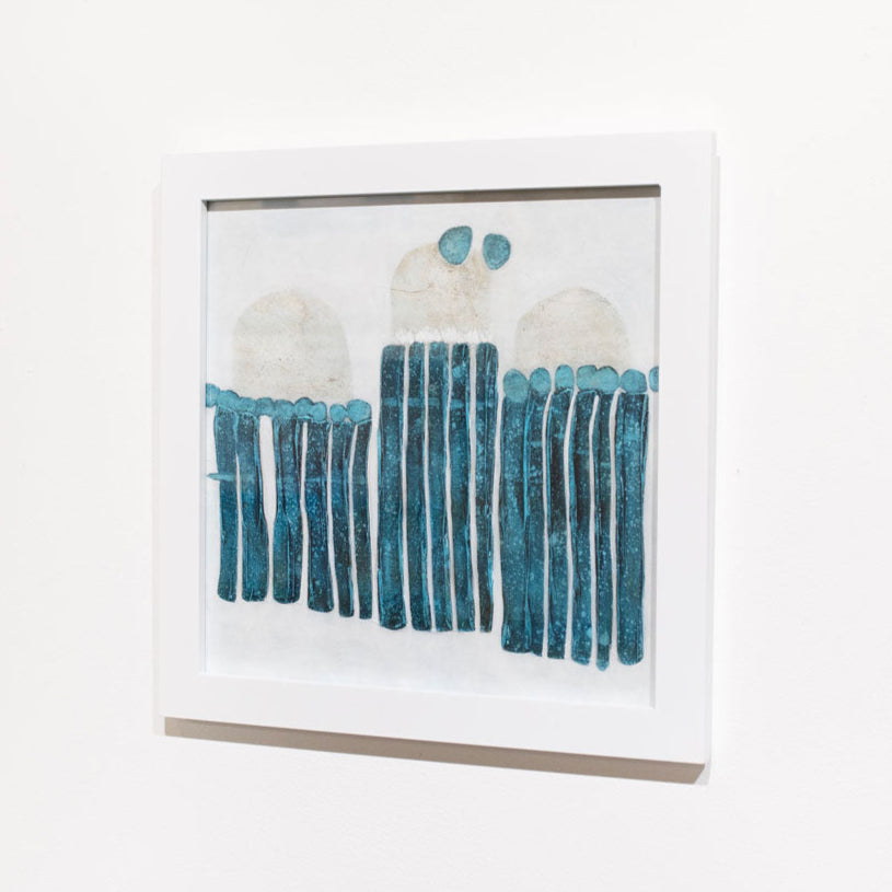 A blue, white, and beige abstract painting framed in a white frame hangs on a white wall.
